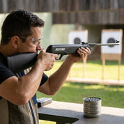 Atirador esportivo realizando treino de pontaria ao alvo com a carabina de pressão CBC Jade New 5.5mm em estande de tiro.