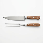 Kit churrasco profissional com faca e garfo trinchante em aço inox e cabo de madeira em fundo branco.