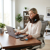 Pessoa sentada confortavelmente no escritorio utilizando o colar cervical inflavel com postura alinhada e sem dor.